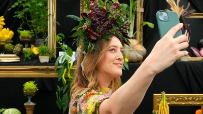 Die jährliche Gartenmesse Chelsea Flower Show in London zieht viele Besucher an. So wie diese Frau mit passender Kopfbedeckung. (Foto: Kirsty Wigglesworth/AP/dpa)