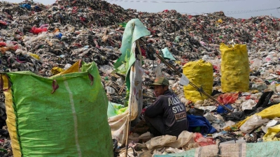 Einblick in die Umweltverschmutzung der Erde: In der Deponie in Depok am Rande von Jakarta türmt sich der Müll. Für diesen Lumpensammler, der sich ausruht, gehört der Anblick zum Alltag. (Foto: Tatan Syuflana/AP)