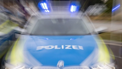 Ein Streifenwagen der Polizei mit eingeschaltetem Blaulicht. (Foto: Daniel Karmann/dpa/Symbolbild)