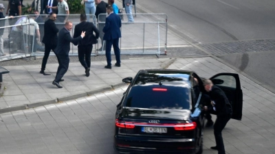 Leibwächter bringen den slowakischen Ministerpräsidenten Robert Fico in einem Auto vom Ort des Geschehens in Sicherheit. (Foto: Radovan Stoklasa/TASR/dpa)