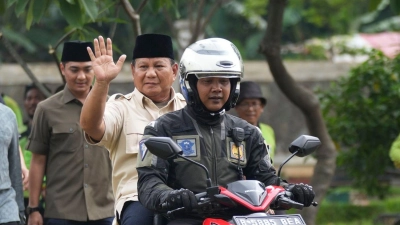 Prabowo Subianto wird von einem Polizisten zum Grab seines Vaters in Jakarta gefahren. (Foto: Tatan Syuflana/AP/dpa)