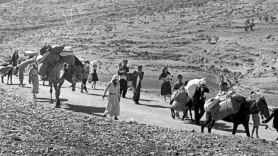 Arabische Flüchtlinge gehen mit ihren Kindern und Habseligkeiten im Gepäck am 9. November 1948 auf einer staubigen Straße von Jerusalem in den Libanon. Die Staatsgründung Israels war 1948 für Hunderttausende von Palästinensern mit Vertreibung und dem Verlust von Heimat verbunden. (Foto: Jim Pringle/AP/dpa)