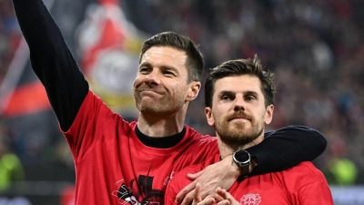 Leverkusens Trainer Xabi Alonso und Jonas Hofmann (r) feiern mit den Fans nach dem Spiel gegen Rom. (Foto: Federico Gambarini/dpa)