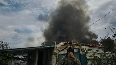 Ein ukrainischer Soldat geht an einem Haus vorbei, das nach einem Beschuss in der Nähe der Frontlinie abgebrannt ist. Russland führt seit Februar 2022 Krieg gegen die Ukraine. (Foto: LIBKOS/AP/dpa)