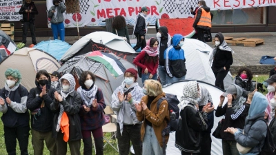 Teilnehmerinnen und Teilnehmer stehen während einer propalästinensischen Demonstration der Gruppe „Student Coalition Berlin“ auf dem Theaterhof der Freien Universität Berlin. (Foto: Sebastian Christoph Gollnow/dpa)