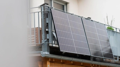 Eine Balkonsolaranlage hängt an einem Wohnhaus. Mit der richtigen Ausrichtung kann man kräftig Stromkosten einsparen. (Foto: Philipp Schulze/dpa)