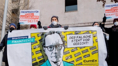 Gerhard Schick (M) nimmt an einer Solidaritätsaktion der Bürgerbewegung Finanzwende für CumEx-Hinweisgeber Eckart Seith teil. (Foto: Christoph Soeder/dpa)