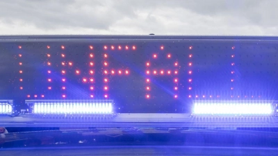 Ein Blaulicht auf dem Dach eines Polizeifahrzeugs mit der LED-Anzeige „Unfall”. (Foto: Daniel Karmann/dpa)