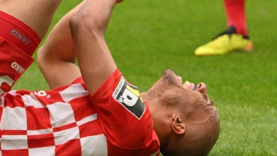 Der Mainzer Karim Onisiwo liegt mit einer verletzten Hand am Boden. (Foto: Torsten Silz/dpa)