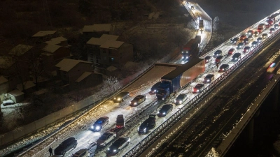 Fahrzeuge stecken auf einer Schnellstraße am Stadtrand von Wuhan fest: In Zentral- und Ostchina fiel viel Schnee. (Foto: Chinatopix/AP/dpa)