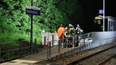 Rettungskräfte stehen an einem Bahnsteig in Kleinheubach. (Foto: Ralf Hettler/dpa)