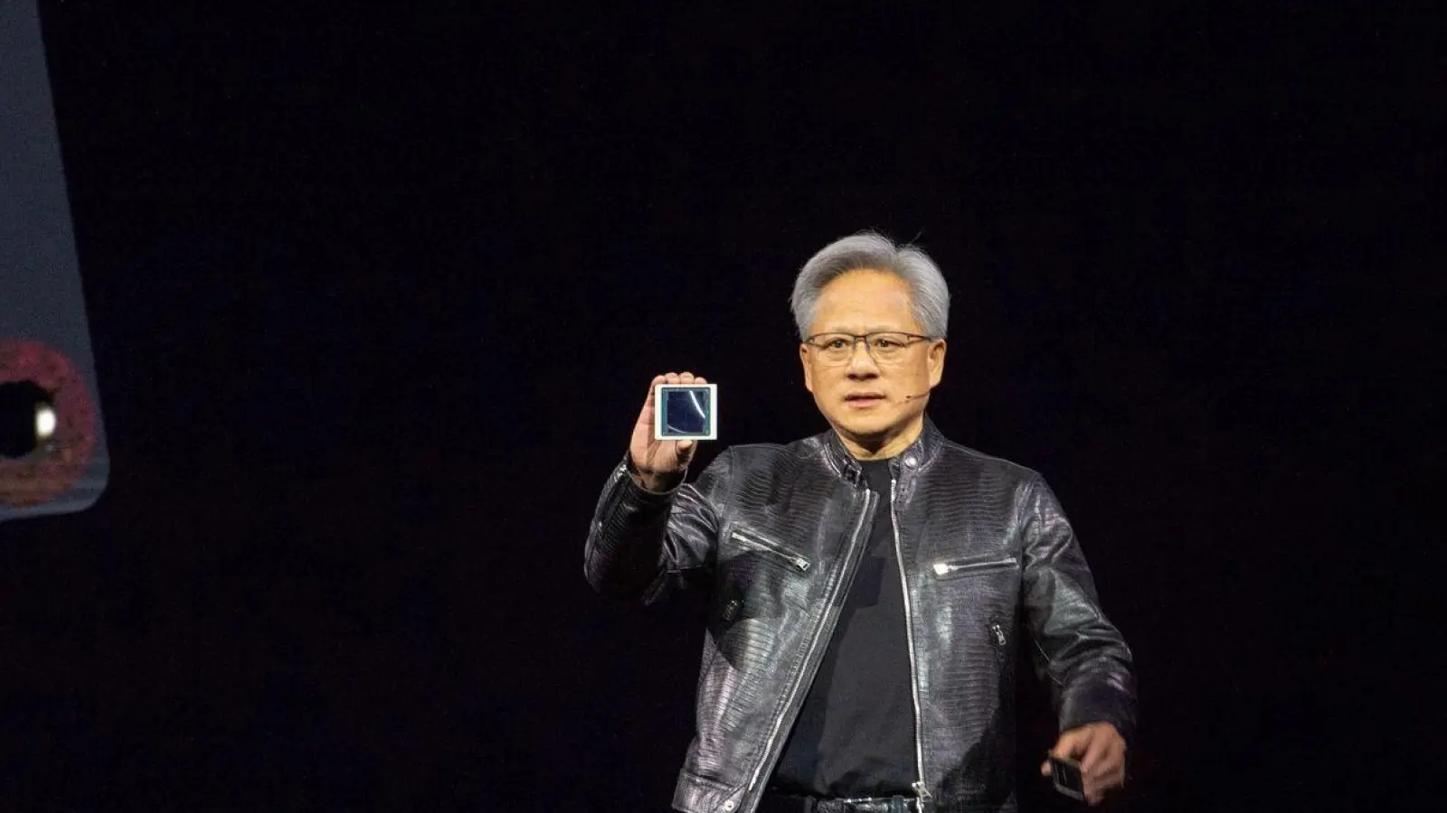 Nvidia-Chef Jensen Huang zeigt auf der hauseigenen Entwicklerkonferenz GTC den neuen KI-Chip Blackwell. (Foto: Andrej Sokolow/dpa)