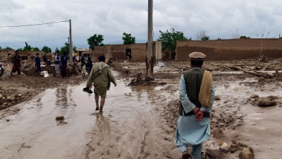 Menschen in der Nähe ihrer beschädigten Häuser nach Überschwemmungen in der nordafghanischen Provinz Baghlan. (Foto: Mehrab Ibrahimi/AP/dpa)