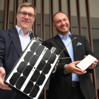 Demonstrativ gute Laune von O2-Manager Jörg Kablitz und OQ-Chef Omar Qaise, die bei der Vorstellung ihres Vorhabens ein Modell eines Satelliten dabeihatten.  (Foto: Wolf von Dewitz/dpa)