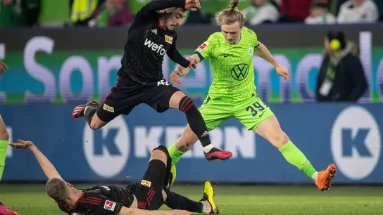 Wolfsburgs Patrick Wimmer (r) versucht sich gegen die Unioner Timo Baumgartl (l) und Josip Juranovic durchzusetzen. (Foto: Swen Pförtner/dpa)
