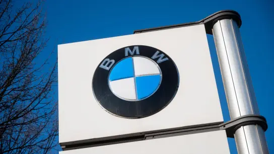 Das Logo von BMW vor einem Werk des Automobilherstellers. (Foto: Christophe Gateau/dpa/Symbolbild)