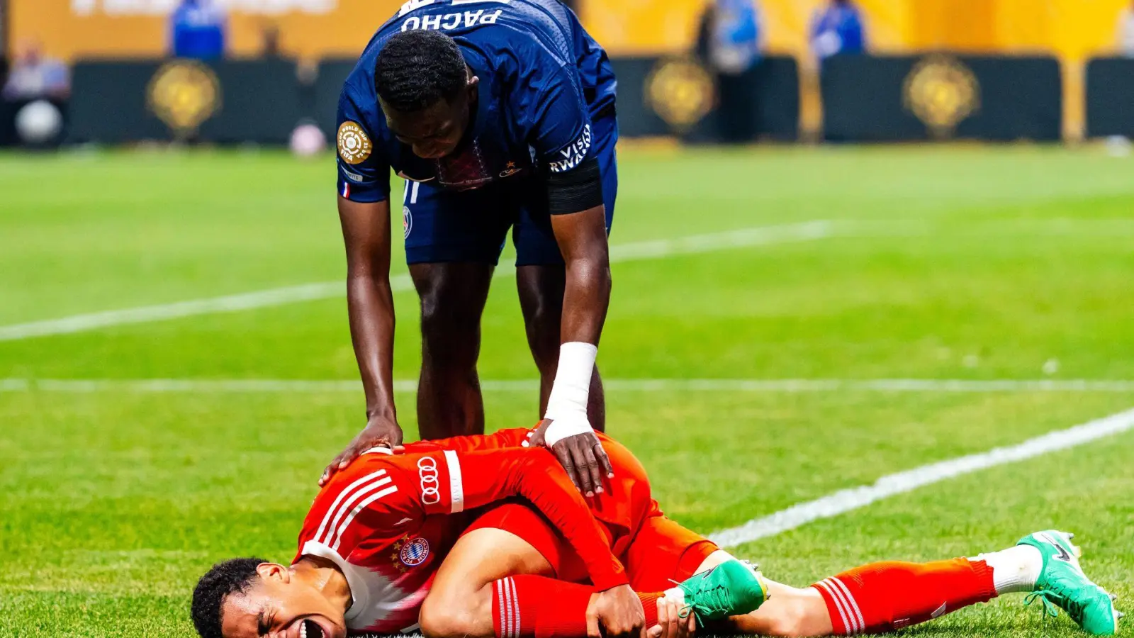 Jamal Musiala liegt mit starken Schmerzen verletzt am Boden. PSG-Profi William Pacho kümmert sich um ihn. (Foto: Malachi Gabriel/ZUMA Press Wire/dpa)