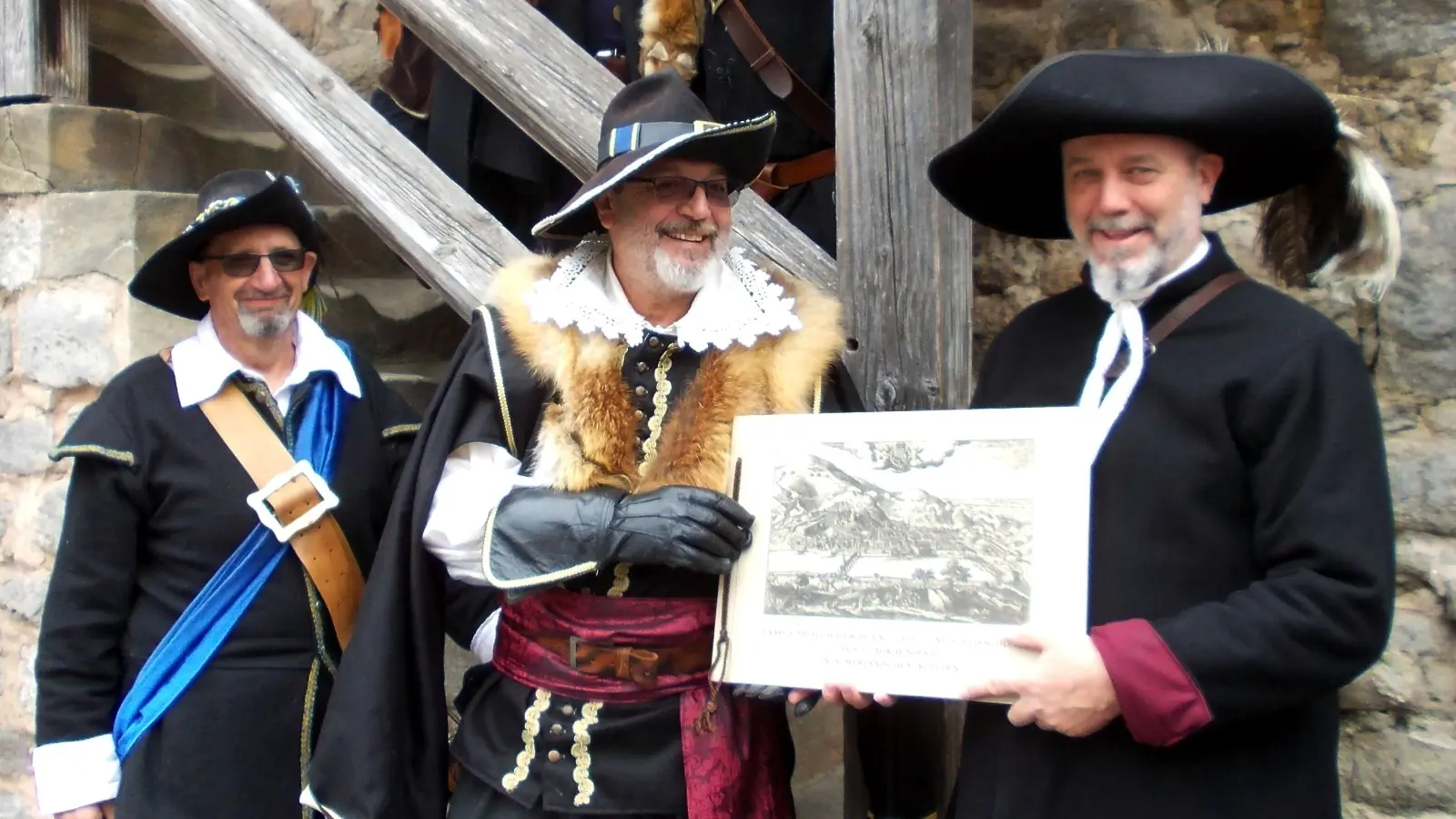 Axel Stolch (rechts) von der Historischen Gesellschaft 1618 und Feldkanzlei von Liebenstein überreichte Helmut Blank, dem Obristen der Getreuen, als Präsent ein Buch mit Stichen des Matthäus Merian. (Foto: Wolfgang Dirian)