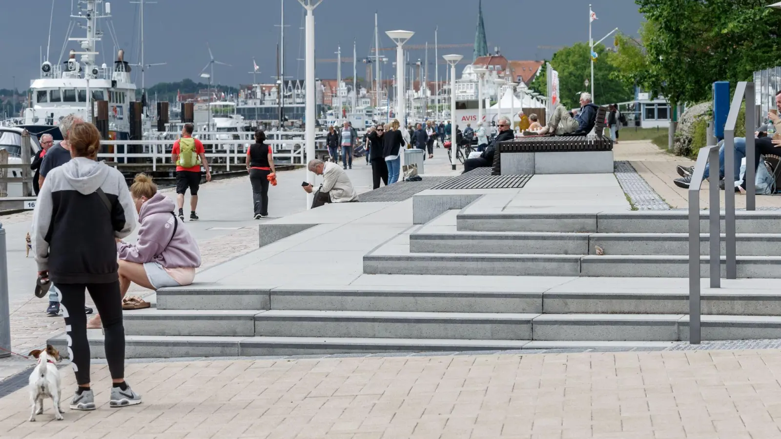Hell gepflasterte Plätze und gestufte Zugänge, auf denen auch gesessen werden kann, sind die Kennzeichen der neugestalteten Travepromenade in Travemünde. (Foto: Markus Scholz/dpa)