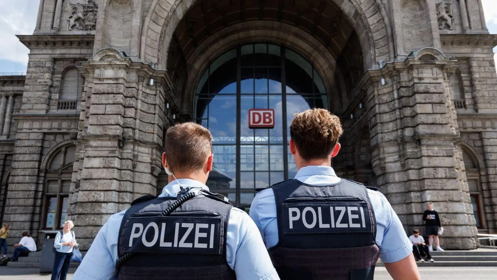 Zwei Polizisten stehen vor dem Nürnberger Hauptbahnhof. (Foto: Daniel Karmann/dpa/Archivbild)