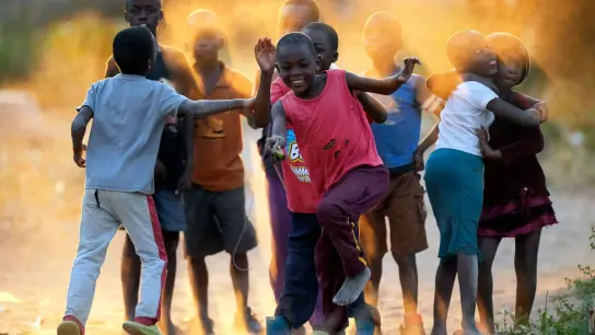 Kinder spielen auf den staubigen Straßen von Epworth, einem Armenviertel am Stadtrand von Harare. (Foto: Tsvangirayi Mukwazhi/AP/dpa)