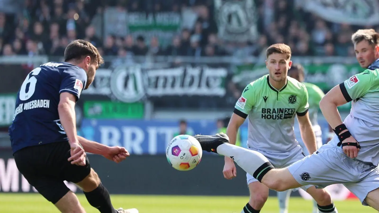 Gino Fechner (l) vom SV Wehen Wiesbaden zieht ab. Hannovers Marcel Halstenberg (r) versucht den Ball zu blocken. (Foto: Jörg Halisch/dpa)