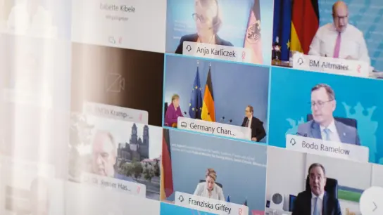 Ministerpräsidenten, Kanzlerin und weitere Vertreter der Bundesregierung sind während der Bund-Länder-Konferenz auf einem Bildschirm. (Foto: Ole Spata/dpa)