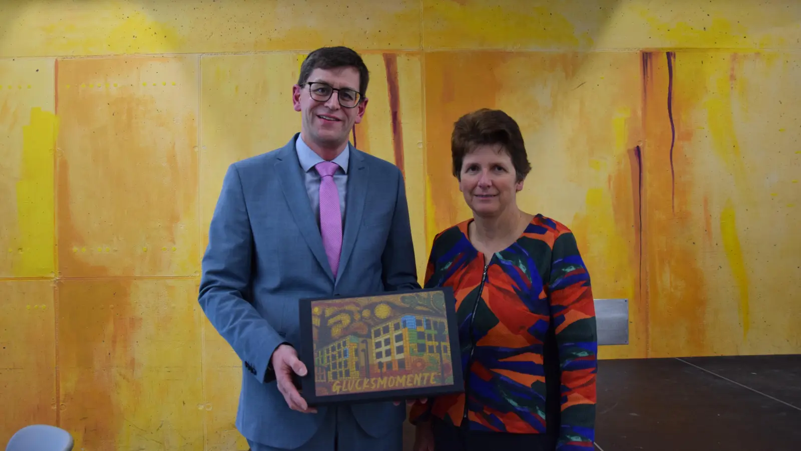 Ministerialbeauftragte Dr. Gabriele Kuen überreichte Schulleiter Tobias Herber eine Box mit dem Konterfei des Platen-Gymnasiums. In dieser soll er seine Glücksmomente aufbewahren. (Foto: Florian Schwab)