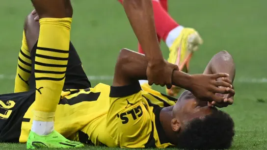 Fällt für Dortmund aus: Karim Adeyemi liegt beim Spiel gegen Leverkusen verletzt auf dem Rasen. (Foto: Bernd Thissen/dpa)