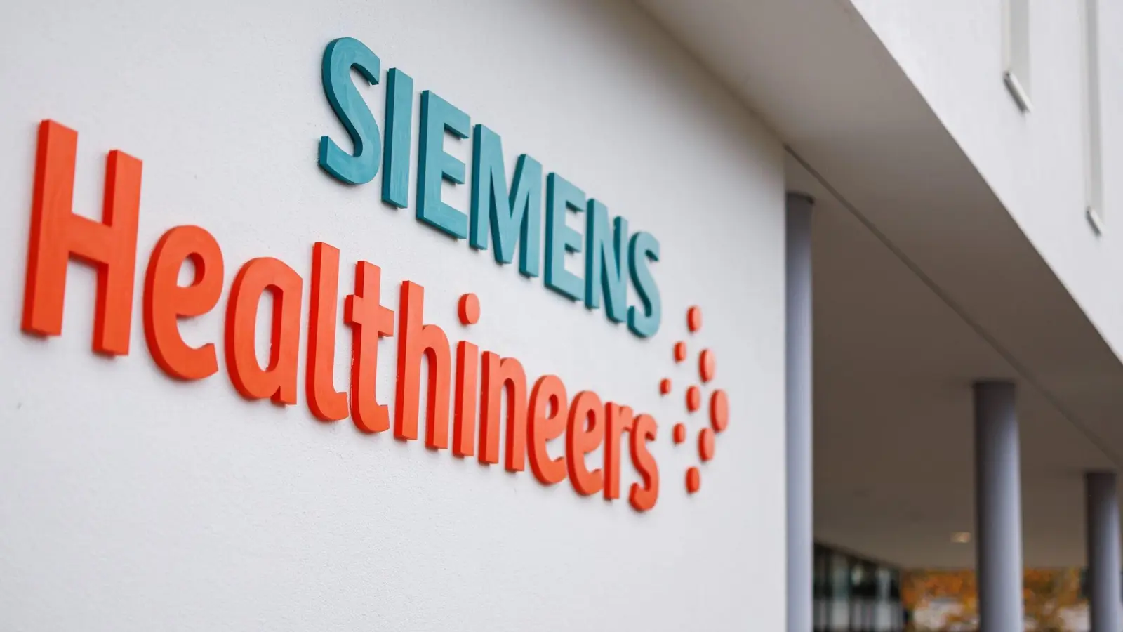 Das Logo und der Schriftzug des Medizintechnikkonzerns Siemens Healthineers steht auf der Fassade eines Unternehmensgebäudes. (Foto: Daniel Karmann/dpa)