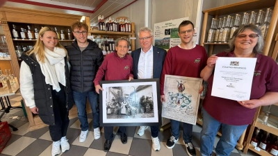 Das Bild von der Feier mit der jüngsten Auszeichnung, der Gründungsurkunde und einem Bild von der 100-Jahr-Feier zeigt (von rechts): Chefin Karola Henninger, Sohn Ruben Henninger, Bürgermeister Hans Henninger, Walter Henninger sowie Landrat Marco Meier mit Freundin Selin Engelhardt. (Foto: Fritz Arnold)