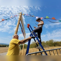 Eleni Martin aus dem P-Seminar ist zugleich Helferin auf dem Festival, genauso wie ihr Vater Uwe Martin. Gemeinsam haben sie die bunten Wimpel und die Lichterkette an den Seiten-Seilen des Torbogens montiert. (Foto: Nina Daebel)