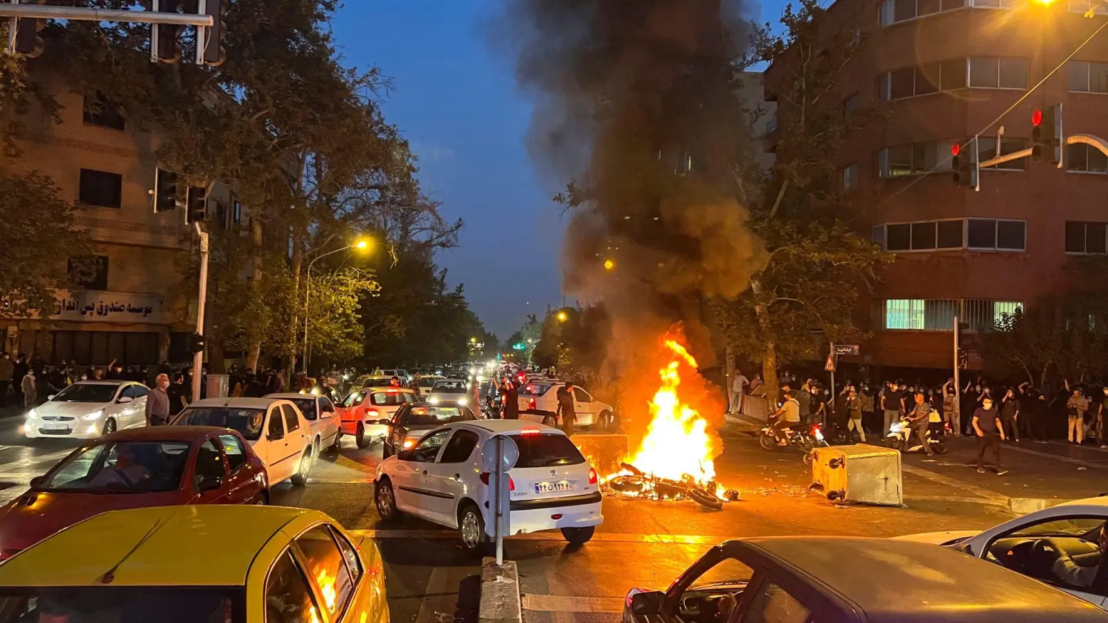 In Teheran brennt am Montagabend ein Polizeimotorrad. (Foto: Uncredited/AP/dpa)