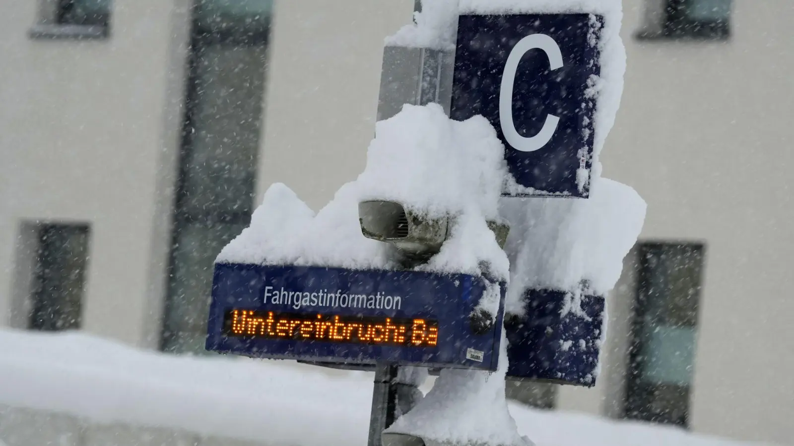 Die Anzeigentafel am Bahnhof in Bad Aibling ist eingeschneit. „Wintereinbruch“ ist darauf zu lesen. (Foto: Uwe Lein/dpa)