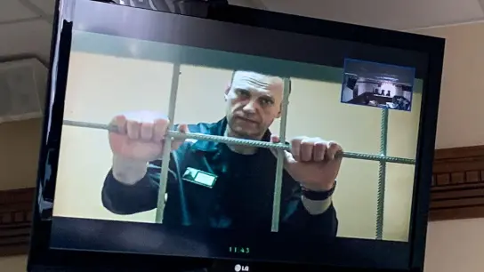 Alexej Nawalny, russischer Oppositionspolitiker, wird in einem Gerichtssaal in Wladimir per Videoverbindung aus dem Gefängnis zugeschaltet und ist auf einem Bildschirm zu sehen. (Foto: Vladimir Kondrashov/AP/dpa)