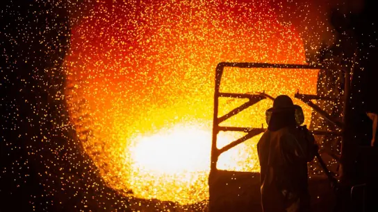 Ein Mitarbeiter reinigt im Stahlwerk der Salzgitter AG eine Roheisenpfanne. (Foto: Christophe Gateau/dpa)