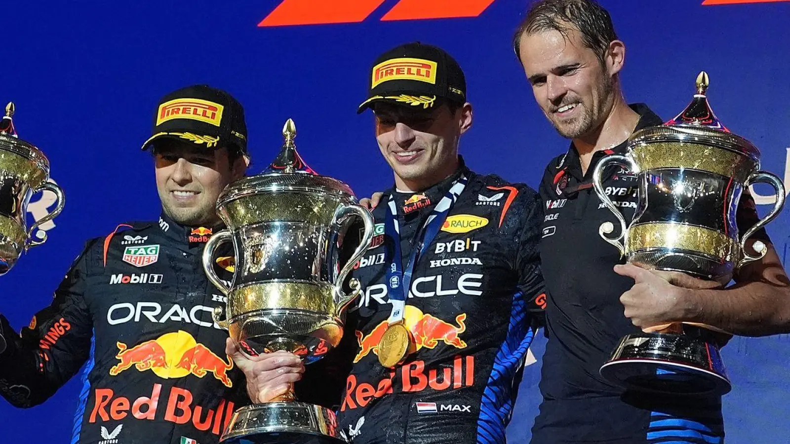 Der Zweitplatzierte Sergio Perez (l-r), Sieger Max Verstappen und Tom Hard von Red Bull stehen auf dem Podium. (Foto: Hasan Bratic/dpa)