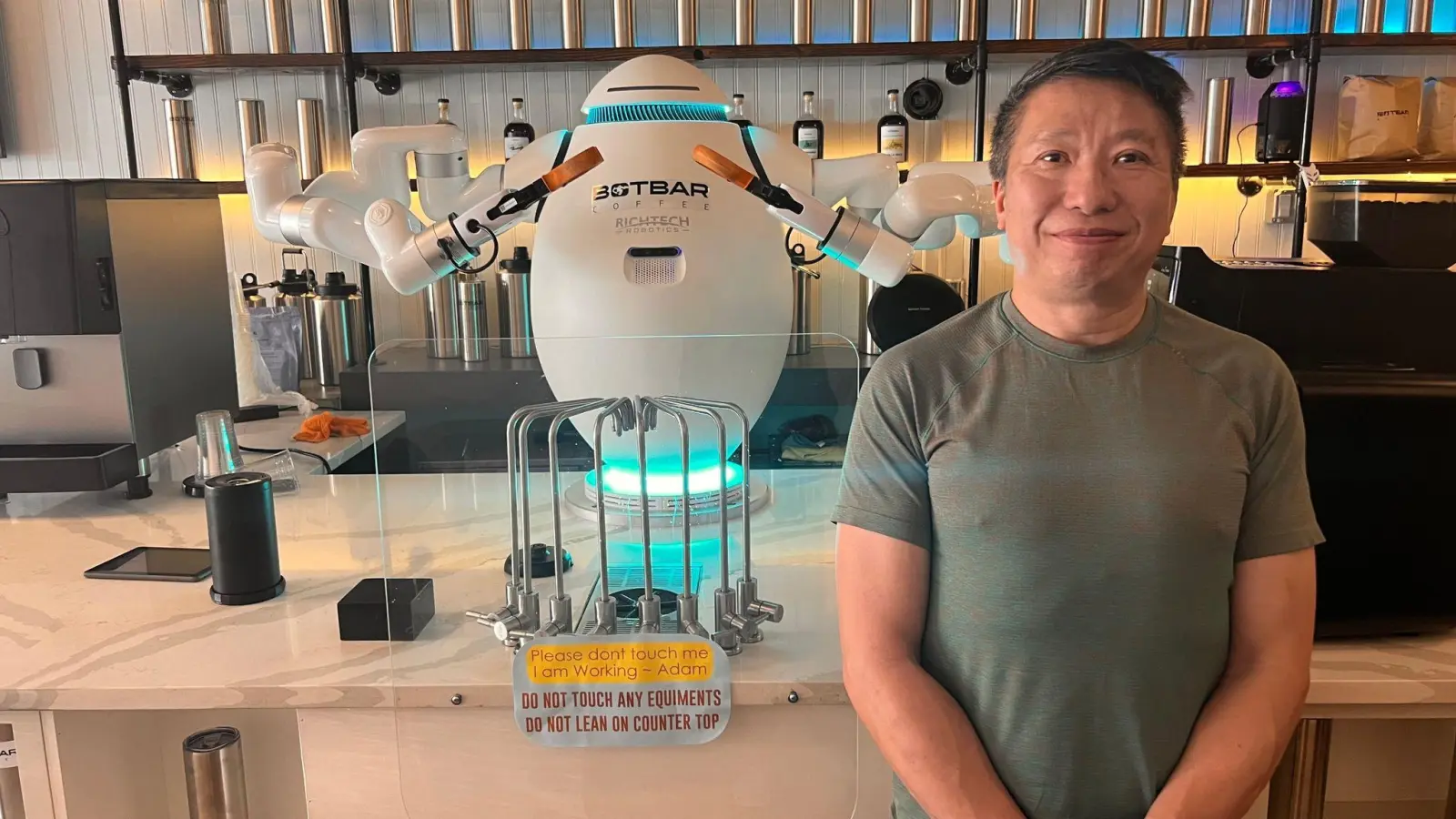 Sunny Lam und sein Barista Adam - der erste Roboter-Kaffeemacher in der US-Ostküstenmetropole New York. (Foto: Benno Schwinghammer/dpa)