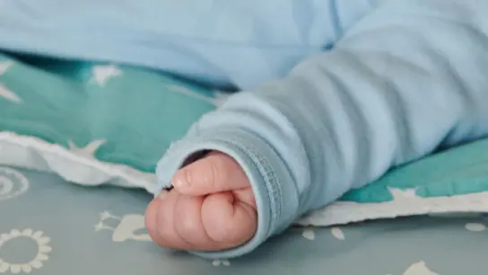 Ein wenige Wochen altes Baby ballt seine Hand zu einer kleinen Faust. (Foto: Annette Riedl/dpa/Symbolbild)