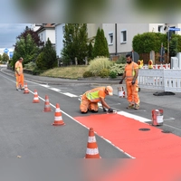 Am Montagnachmittag liefen noch letzte Markierungsarbeiten – mit dem roten Farbtopf wurde die Fahrradspur eingezeichnet. Im Laufe des Dienstags soll aber alles rundum abgeschlossen sein. (Foto: Ute Niephaus)