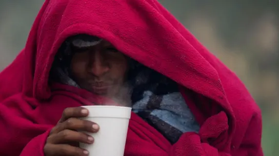 Kaffee gegen das kalte Wetter: Ein Migrant aus Venezuela in einem behelfsmäßigen Lager an der Grenze zwischen den USA und Mexiko. (Foto: Fernando Llano/AP/dpa)