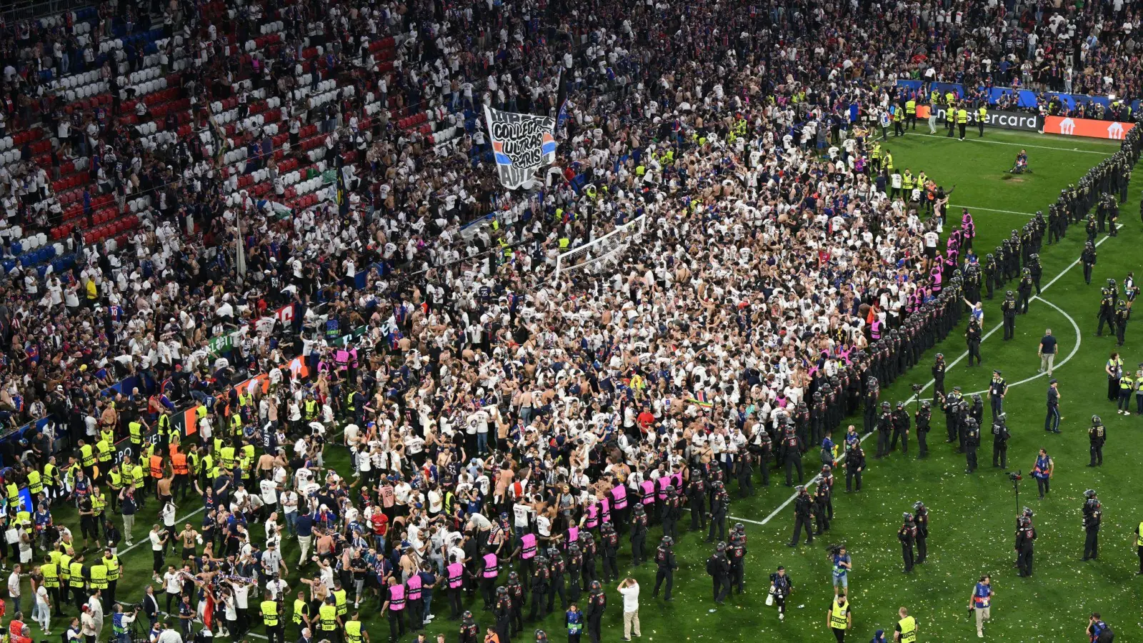 Party auf dem Rasen: Pariser Fans stürmen aus ihrem Block. (Foto: Peter Kneffel/dpa)
