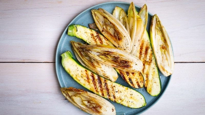 Die länglich geschnittenen Zucchini- und Chicorée-Streifen werden mit einer Marinade aus Olivenöl, Limettensaft, Salz und Pfeffer eingepinselt, dann auf jeder Seite 2–3 Minuten gegrillt. (Foto: Ariane Bille/BVEO/dpa-tmn)