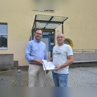 Andreas May (rechts) ist Anwohner im Kernort von Wilburgstetten. Im Namen von 106 Bürgerinnen und Bürgern überreichte er den Antrag auf eine Temporeduzierung im Wohnbereich an Bürgermeister Michael Sommer (links). (Foto: Peter Tippl)