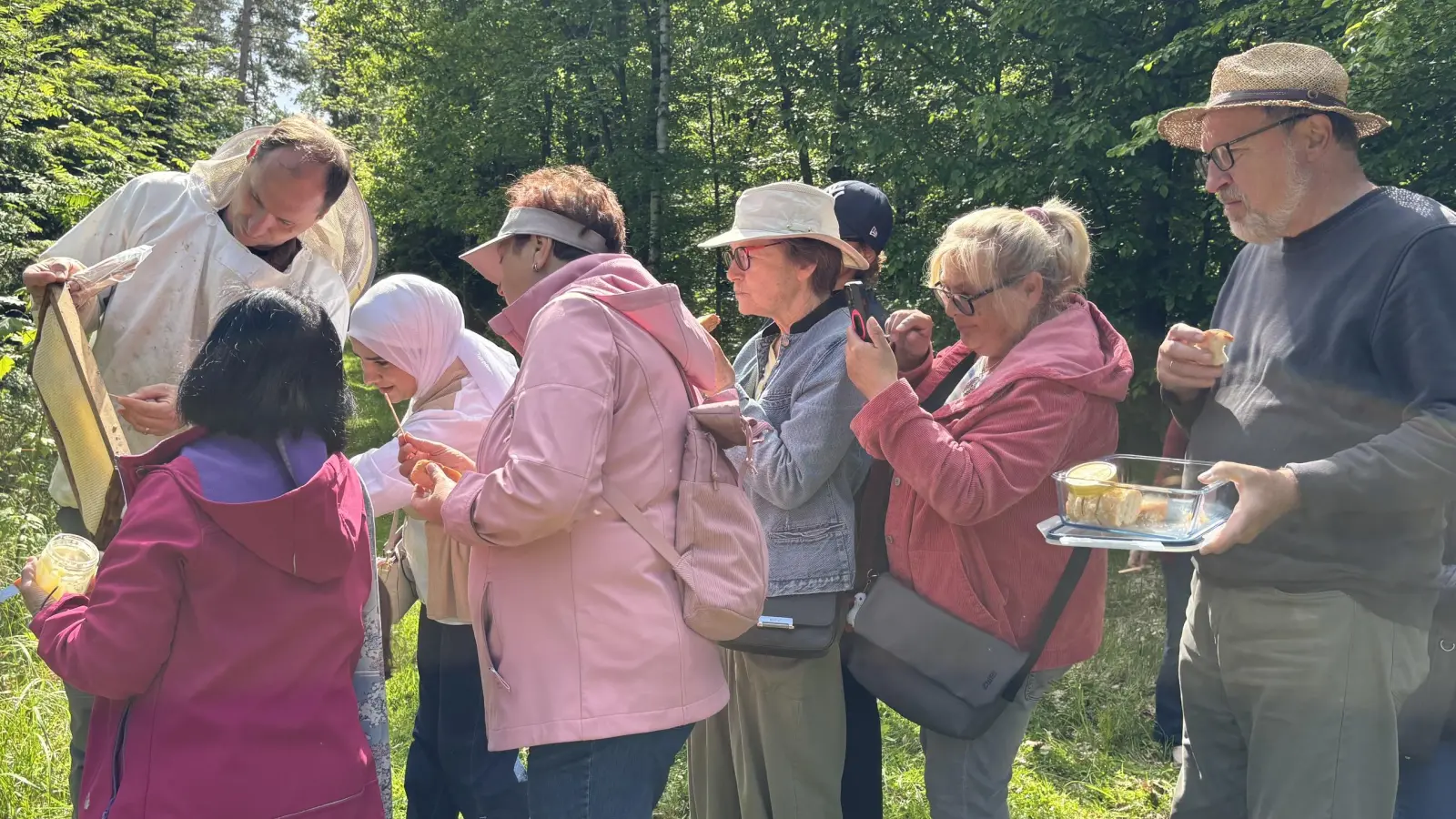 Imker Andreas Feuerabend (links) erläuterte den Frauen des Markt Erlbacher Unterstützerkreises Asyl und der Neustädter Walk- und-Talk-Gruppe Wissenswertes rund um Bienen.  (Foto: Nicole Gunkel)