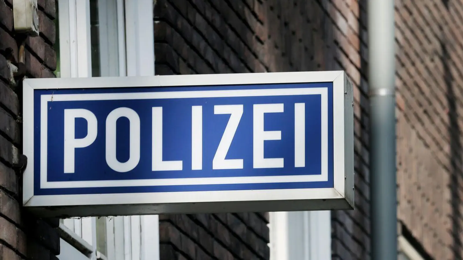 Ein Schild mit der Aufschrift „Polizei“ hängt an einem Polizeipräsidium. (Foto: Roland Weihrauch/dpa/Symbolbild)