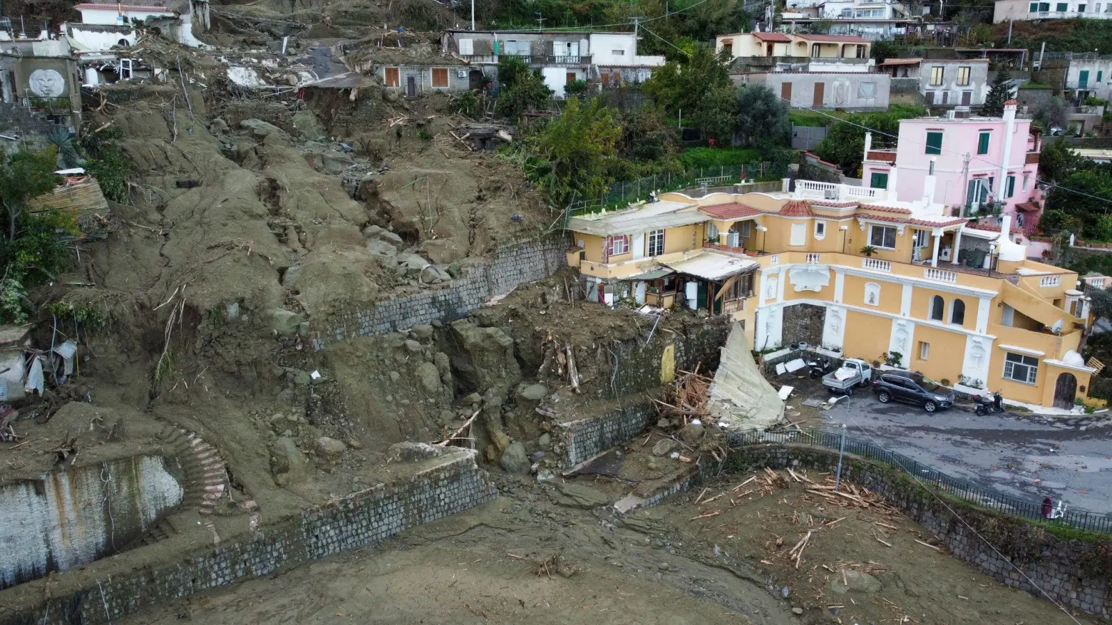 Eine Luftaufnahme zeigt Häuser, die durch das Unwetter und die einhergehenden Erdrutsche beschädigt wurden. Die Folgen des Unwetters kosteten mehreren Menschen das Leben. (Foto: Salvatore Laporta/AP/dpa)