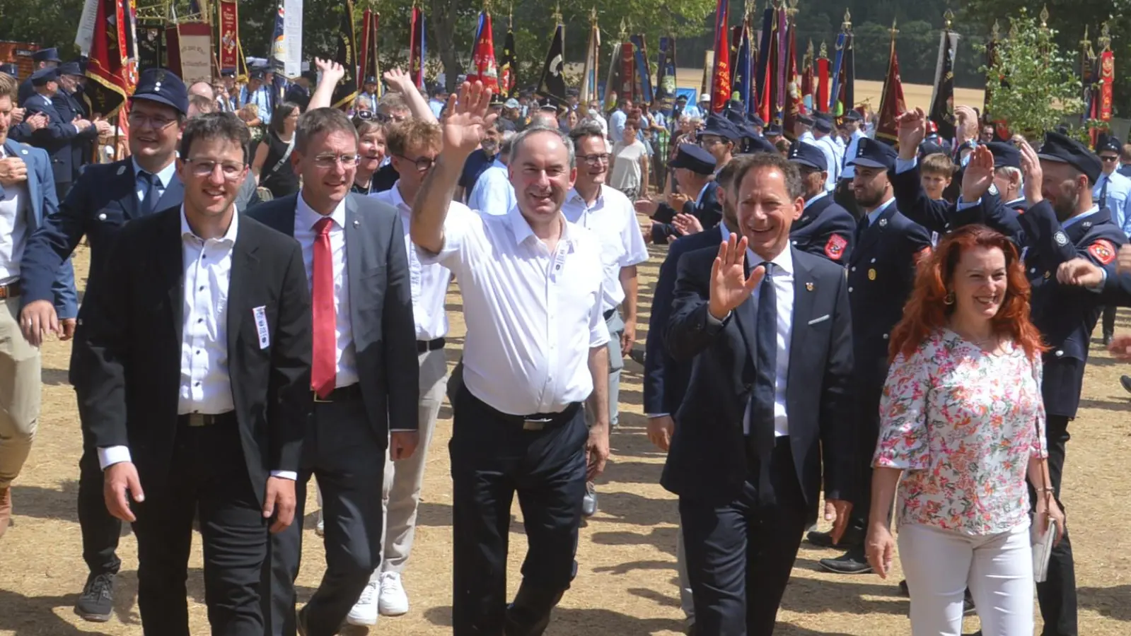 Gesäumt von Fahnen und Feuerwehr zogen die Ehrengäste mit dem Schirmherrn Hubert Aiwanger (Bildmitte) in das Festzelt ein. (Foto: Peter Tippl)
