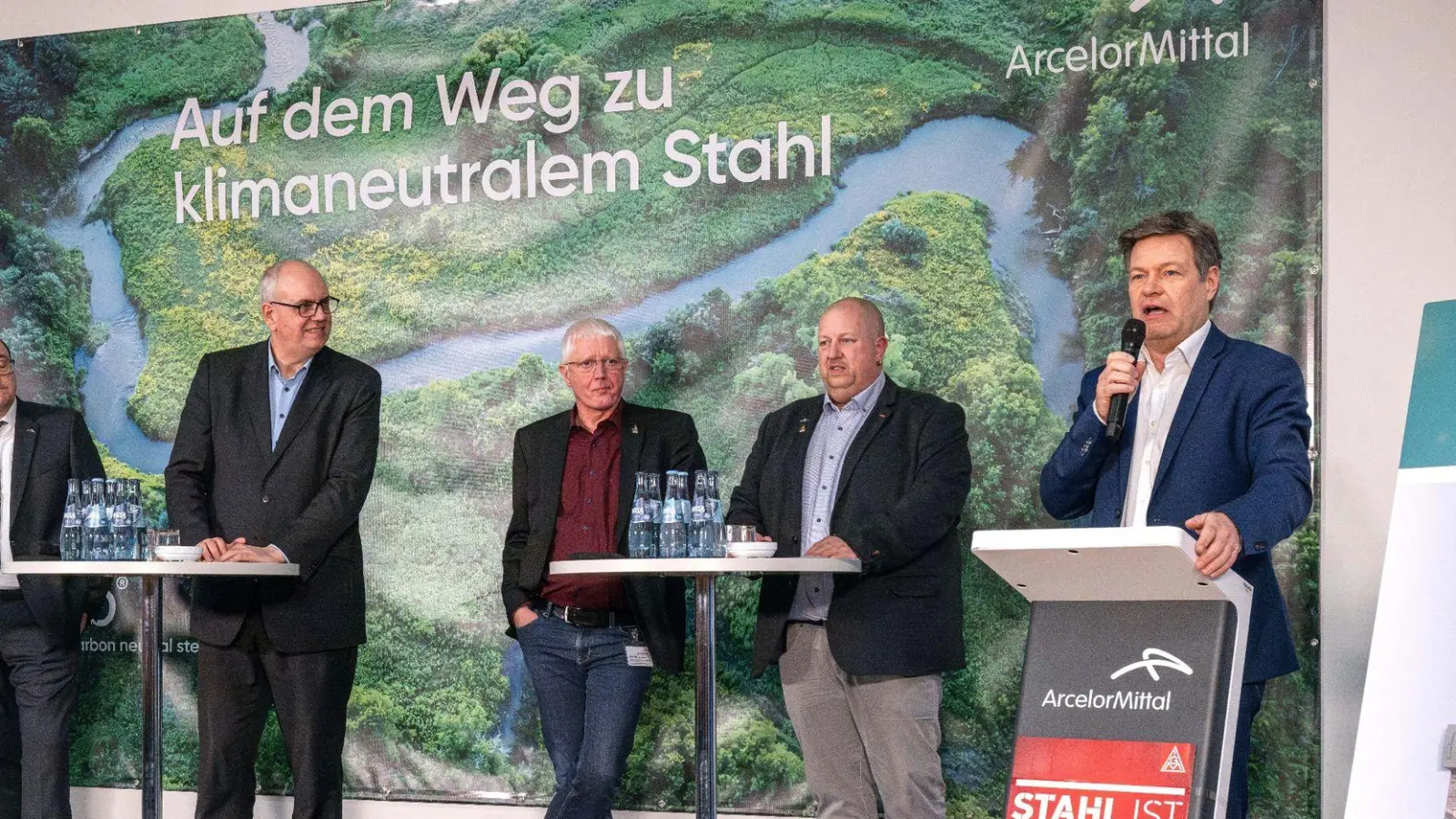 Wirtschaftsminister Robert Habeck (r) verkündet bei einer Betriebsversammlung die Förderzusage für den Umbau des Bremer Stahlwerks. (Foto: Sina Schuldt/dpa)