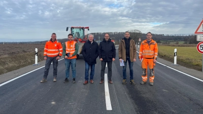 Auch der vierte Abschnitt der Erschließungsstraße ist jetzt fertig. Das Foto zeigt Bürgermeister Jürgen Geier (Dritter von rechts) mit Vertretern der Baufirma, des Planungsbüros und des Bauhofs an dem neuen Teilstück. (Foto: Gemeinde Dombühl)